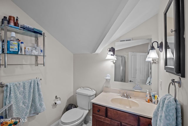 bathroom with vanity, toilet, a shower with shower door, and vaulted ceiling