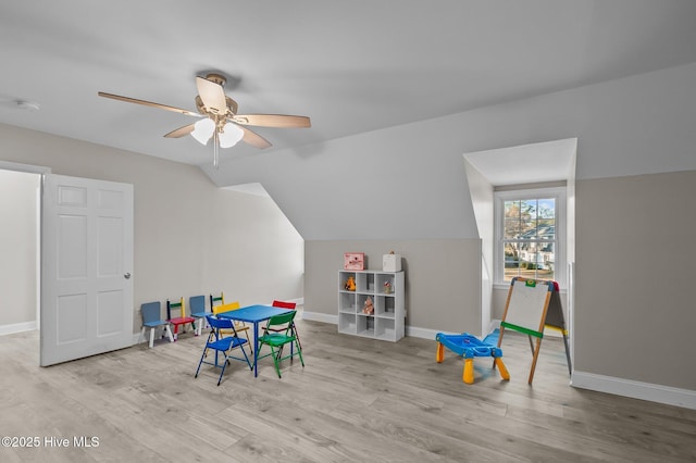 playroom featuring light hardwood / wood-style floors, vaulted ceiling, and ceiling fan