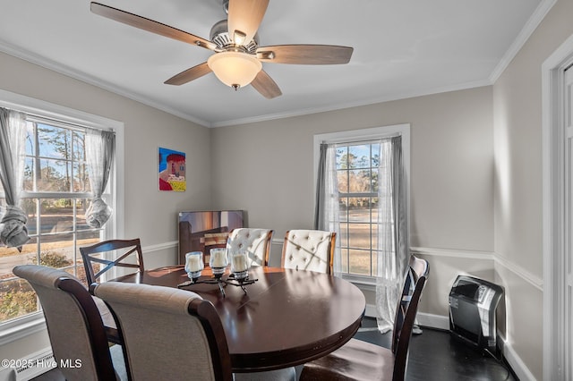 dining room with crown molding, heating unit, and ceiling fan