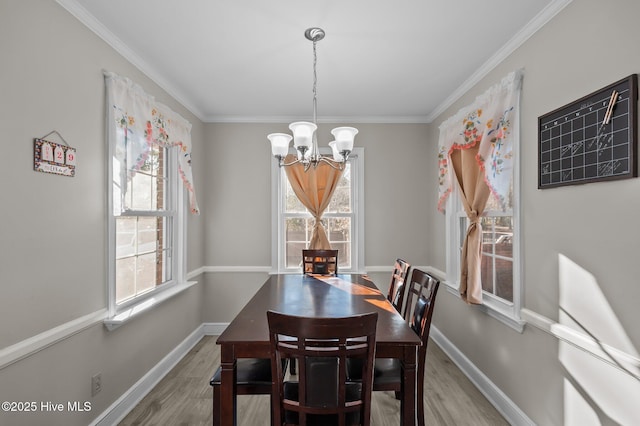 dining area with wood-type flooring, an inviting chandelier, and crown molding