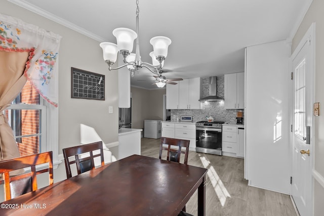 dining area with light hardwood / wood-style flooring, ceiling fan with notable chandelier, and crown molding