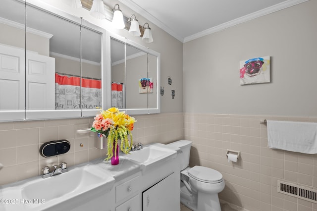 bathroom featuring tile walls, toilet, vanity, and ornamental molding