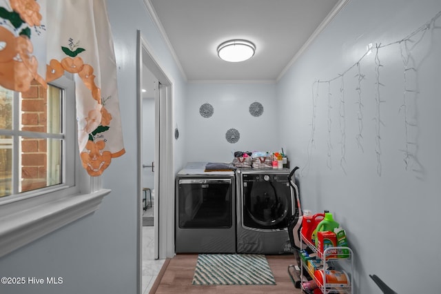 washroom featuring light hardwood / wood-style flooring, crown molding, and separate washer and dryer