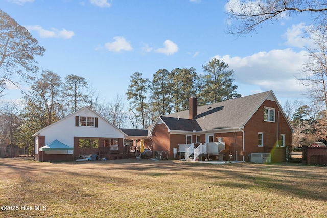 back of property with central AC and a yard