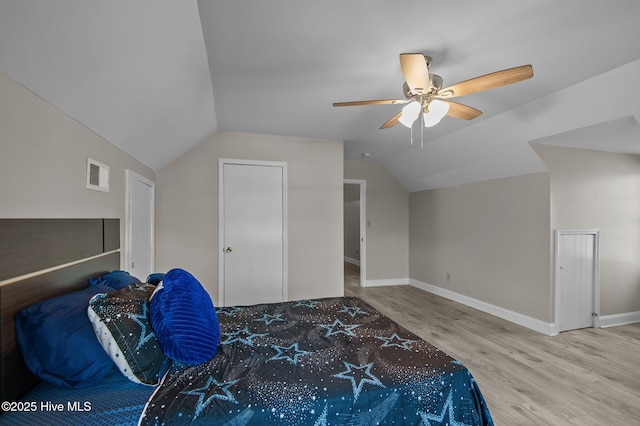 bedroom with ceiling fan, vaulted ceiling, and hardwood / wood-style flooring