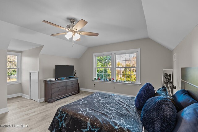 bedroom featuring ceiling fan, vaulted ceiling, and multiple windows