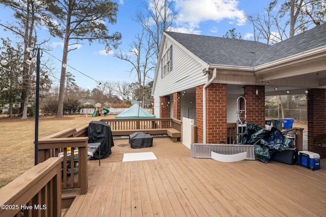 wooden terrace featuring a playground and area for grilling