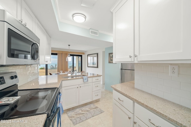 kitchen featuring stainless steel appliances, white cabinetry, sink, and backsplash