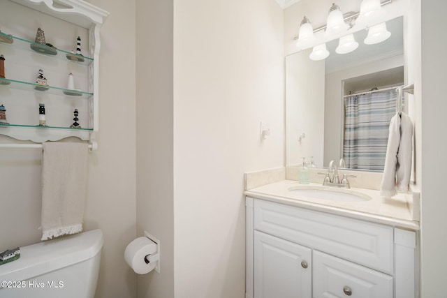 bathroom with ornamental molding, vanity, and toilet