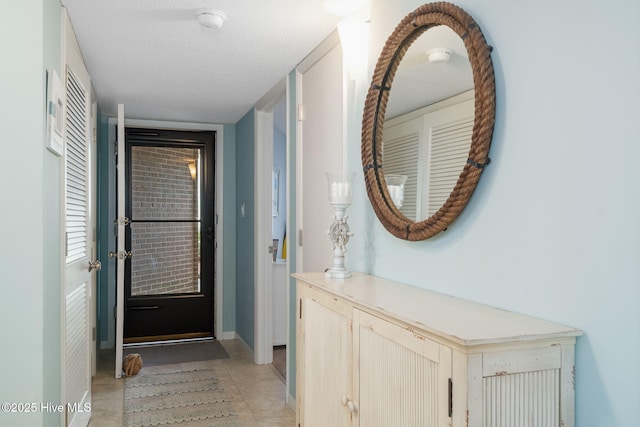 doorway to outside with a textured ceiling