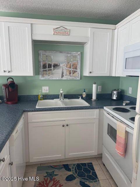 kitchen featuring white cabinets, white appliances, sink, and light tile patterned floors