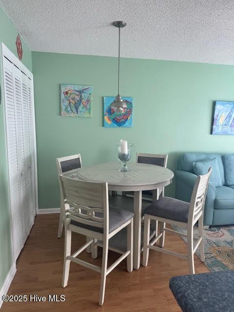 dining room featuring hardwood / wood-style floors and a textured ceiling