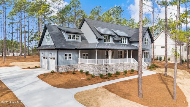 modern farmhouse style home featuring a garage, metal roof, covered porch, a standing seam roof, and board and batten siding