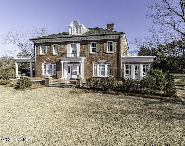 colonial inspired home with a front lawn