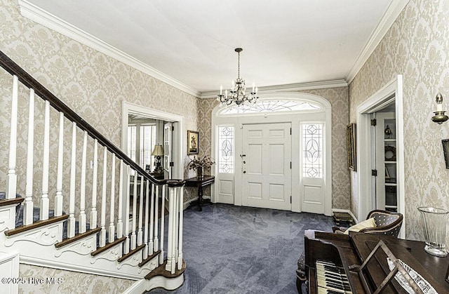 carpeted foyer entrance featuring crown molding and a chandelier