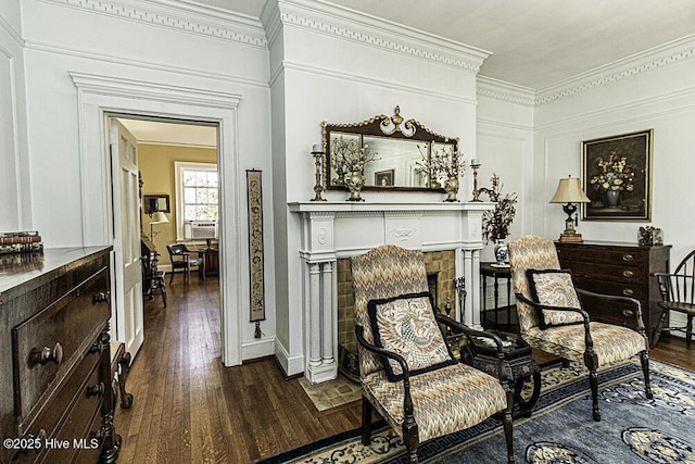 living area with a tiled fireplace, dark hardwood / wood-style floors, and crown molding