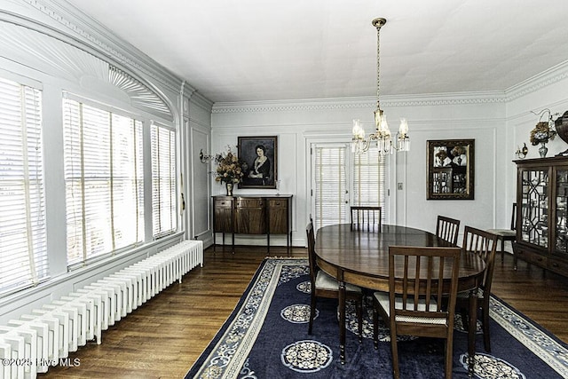 dining space featuring crown molding, dark hardwood / wood-style flooring, radiator, and a chandelier