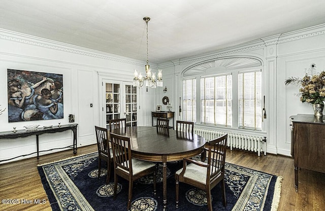 dining area with dark hardwood / wood-style floors, radiator heating unit, french doors, and a notable chandelier