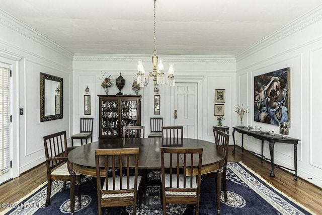 dining space with dark hardwood / wood-style flooring, an inviting chandelier, and ornamental molding