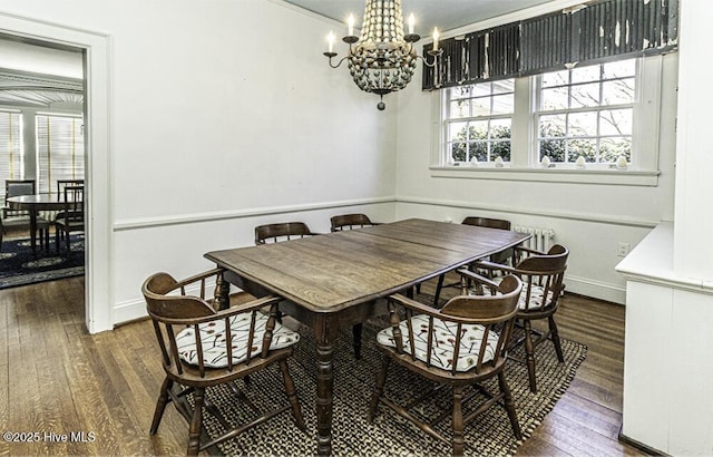 dining space featuring dark hardwood / wood-style floors and an inviting chandelier