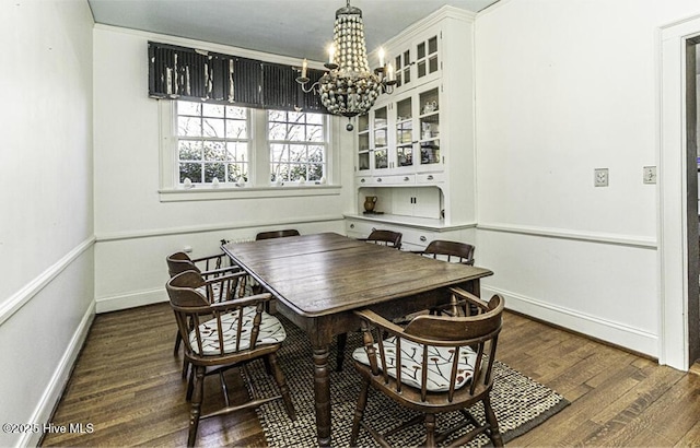 dining room featuring dark hardwood / wood-style floors, ornamental molding, and a chandelier