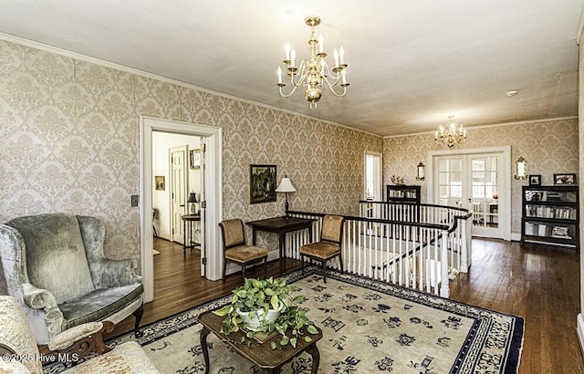 living room with dark wood-type flooring, ornamental molding, french doors, and a notable chandelier