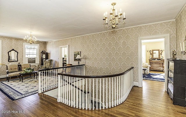 corridor with wood-type flooring, crown molding, and a chandelier