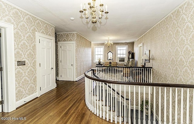 hallway with hardwood / wood-style floors, crown molding, and an inviting chandelier