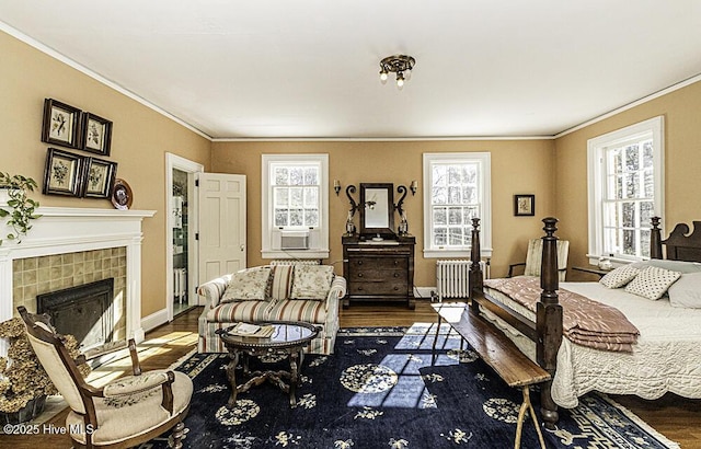 bedroom featuring radiator, ornamental molding, multiple windows, and hardwood / wood-style flooring