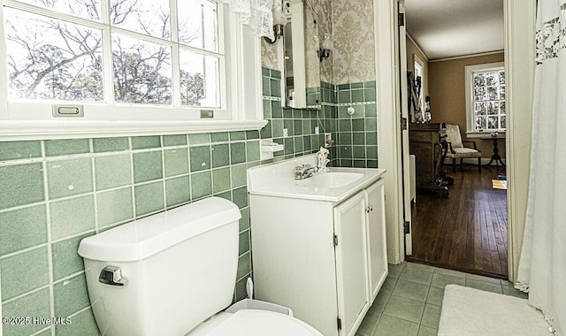 bathroom featuring toilet, a wealth of natural light, tile patterned floors, and vanity