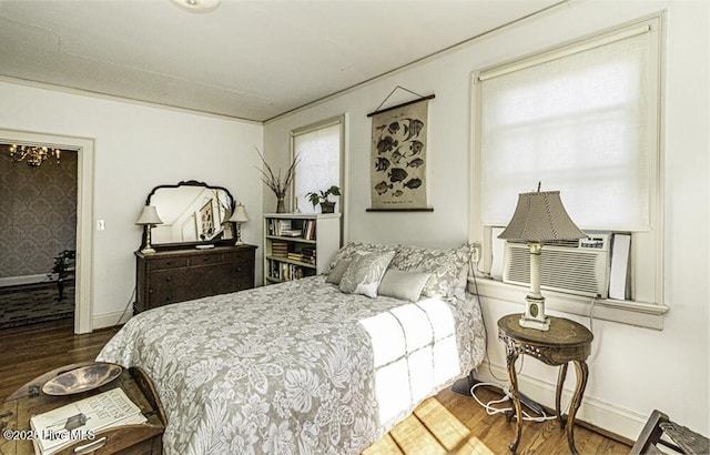 bedroom with a chandelier, crown molding, and hardwood / wood-style flooring