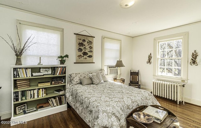 bedroom with cooling unit, dark hardwood / wood-style floors, radiator, and ornamental molding