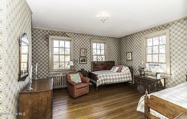 bedroom featuring dark hardwood / wood-style floors, radiator heating unit, and crown molding