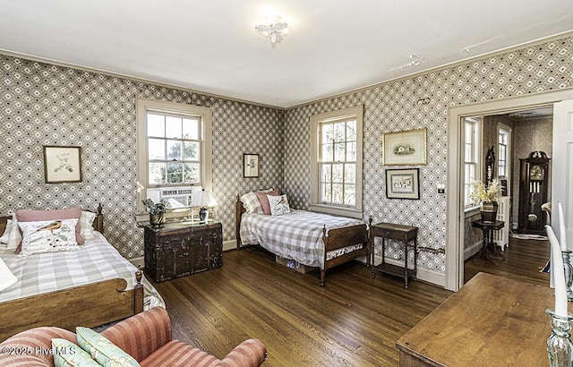 bedroom featuring dark wood-type flooring, crown molding, and multiple windows