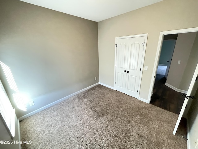 unfurnished bedroom featuring a closet and dark colored carpet