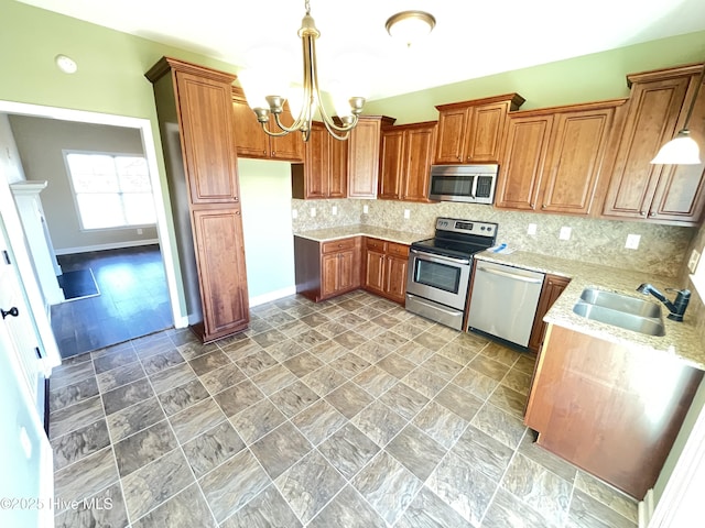 kitchen featuring backsplash, stainless steel appliances, sink, decorative light fixtures, and a notable chandelier