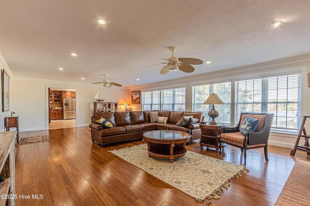 living room with ceiling fan, wood-type flooring, and ornamental molding