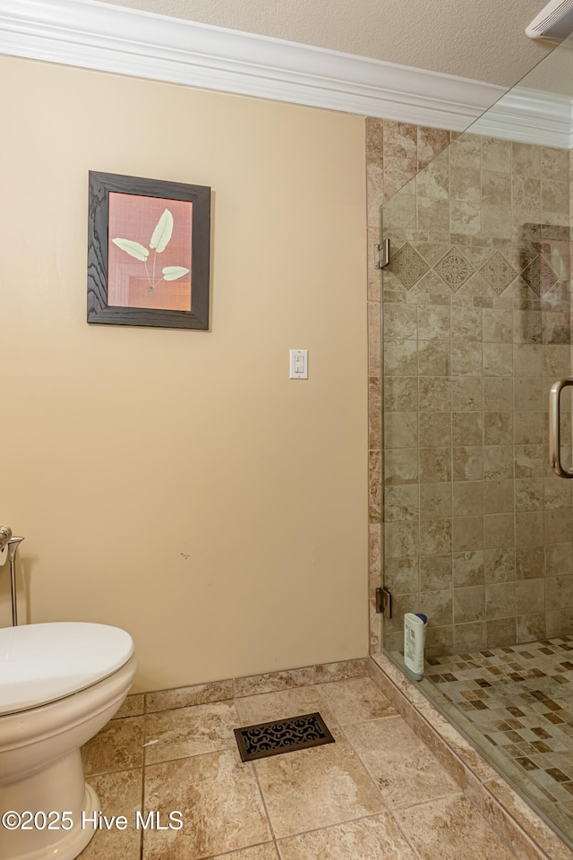 bathroom featuring crown molding, a shower with door, a textured ceiling, and toilet