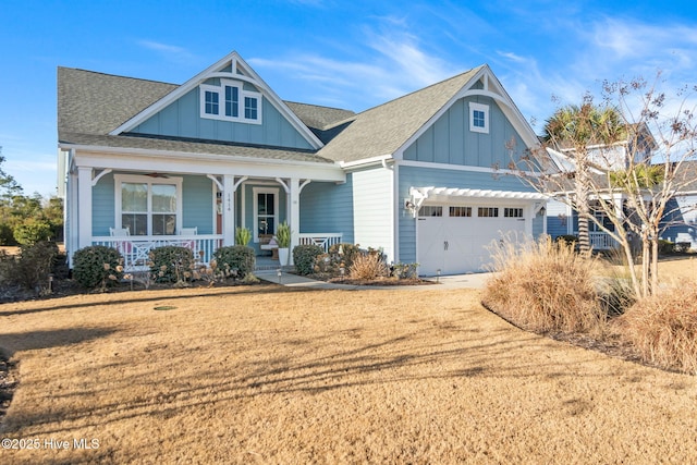 view of front facade featuring a garage, a front lawn, and covered porch