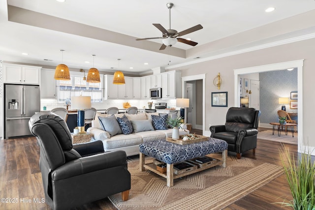 living room with a tray ceiling, crown molding, and dark hardwood / wood-style floors