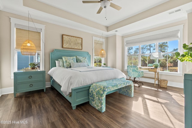 bedroom with dark hardwood / wood-style flooring, crown molding, and a raised ceiling