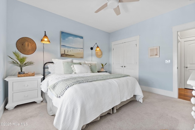 bedroom featuring light colored carpet, a closet, and ceiling fan