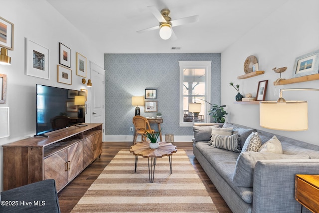 living room featuring dark wood-type flooring and ceiling fan