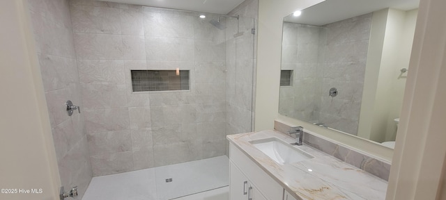 bathroom featuring vanity and tiled shower