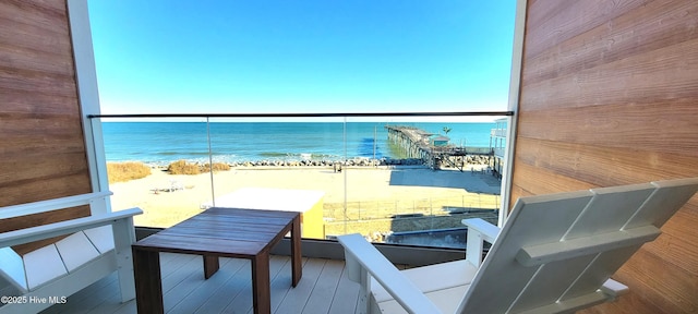 balcony featuring a water view and a beach view