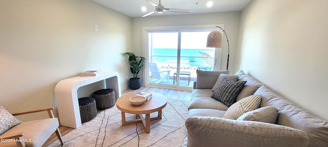 living room featuring light hardwood / wood-style flooring and ceiling fan