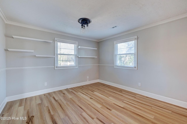 empty room with crown molding, a textured ceiling, and light wood-type flooring