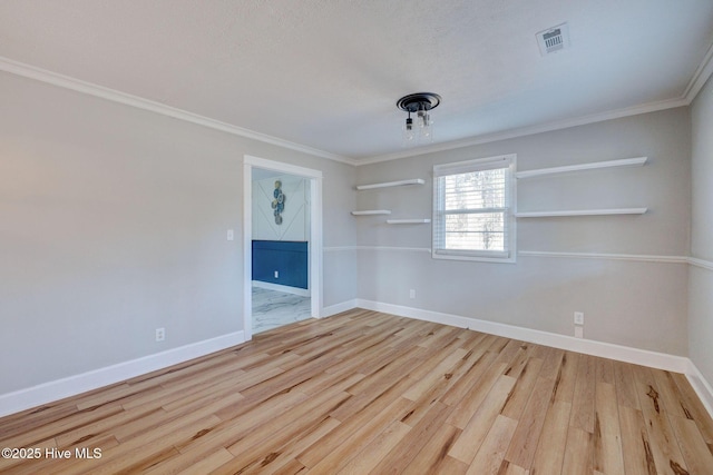 empty room featuring crown molding and light hardwood / wood-style flooring