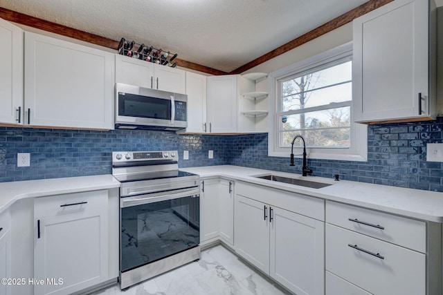 kitchen with sink, white cabinets, and appliances with stainless steel finishes