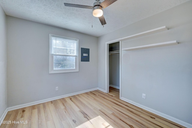 unfurnished bedroom featuring ceiling fan, a textured ceiling, light wood-type flooring, and a closet